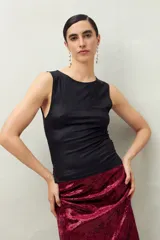 Top sin mangas, de cuello redondo, color marrón oscuro con acabado metalizado y textura acanalada. Calce ajustado al cuerpo.