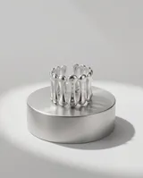 Anillo ancho de acero plateado con diseño de barras paralelas y pequeñas aplicaciones brillantes.