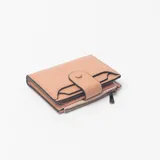 Billetera compacta de cuero sintético color rosa, con cierre de broche a presión y compartimento con cierre perimetral.