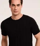 Remera negra de algodón con textura trenzada, cuello redondo y mangas cortas.