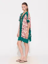 Poncho verde esmeralda con paneles estampados en tonos rosa y beige, cuello en V y mangas cortas.