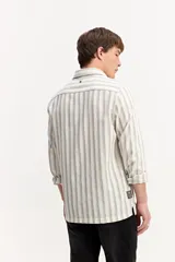 Camisa de manga larga color beige, de tejido texturado con cierre frontal de botones y cuello camisero clásico.
