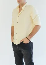 Camisa color amarillo claro, de corte clásico, con cuello mao y mangas largas con puños abotonados.