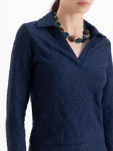 Top de manga larga en color azul marino, confeccionado en tejido con textura calada y diseño ajustado al cuerpo, con cuello tipo polo y escote en V.