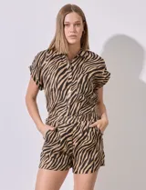 Short de lino con estampado animal print de cebra en tonos marrón y negro. Tiene pretina ancha elastizada y bolsillos inclinados en la parte delantera.