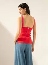 Top rojo de punto jacquard, corte ajustado, con breteles fucsia, tajos laterales y cierre en la espalda.