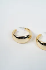 Par de aros tipo argolla de diseño grueso y superficie lisa con acabado brillante.