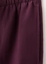 Pantalon de lino color bordo, de corte recto y tiro medio, con cintura elastizada y bolsillos laterales.