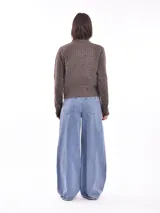 Cárdigan tejido color gris claro con diseño trenzado, cuello redondo y cierre frontal con botones marrones.