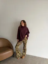 Pantalón tipo oxford de tiro alto, con estampado abstracto en tonos tierra, negro y crema. Presenta un corte ajustado en la parte superior y acampanado desde la rodilla hacia abajo.