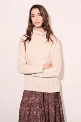 Sweater negro de cuello alto con tajos laterales y detalle de línea plateada en puños y ruedo.