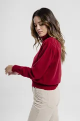 Polera de tejido de punto color negro, con cuello tortuga alto y puños y ruedo acanalados.