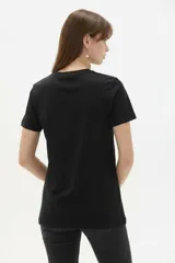 Remera de algodón blanca de manga corta y cuello redondo, con estampa frontal que incluye un corazón rojo y letras con diseño animal print.