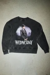 Buzo de cuello redondo con efecto lavado, manga larga y puños en rib. Presenta una estampa frontal de la serie Wednesday con acabado desgastado.