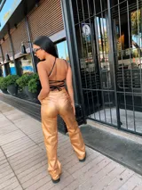 Pantalón de vestir dorado, de corte wide leg y tiro alto.