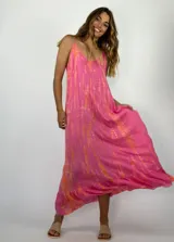 Vestido largo de tirantes finos con diseño holgado y fluido. Presenta un estampado tipo tie-dye en tonos fucsia y naranja, con un ruedo con volado.
