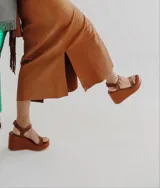 Sandalias de cuero color marrón chocolate con plataforma y taco corrido. Tira ancha sobre los dedos y tira al tobillo con hebilla dorada.