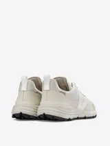 Zapatillas Veja Dekkan color crema, con paneles de malla y superposiciones de cuero sintético. Logo "V" en los laterales y suela Vibram.