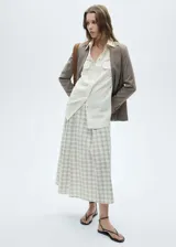 Falda midi de tiro alto con estampado de cuadros en tonos neutros. Presenta cierre lateral con cremallera, diseño evasé y costuras decorativas. Confeccionada en tejido ligero de algodón.