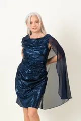 Vestido de fiesta azul con lentejuelas y capa de gasa transparente.