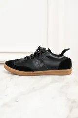 Zapatillas urbanas de cuero negro con puntera y talón de gamuza negra, detalles en cuero con textura de reptil y suela de goma color caramelo.
