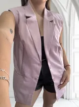 Chaleco sastrero largo color lila, sin mangas, con solapas y cierre con dos botones.