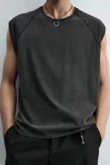 Camiseta tank gris con efecto lavado, de corte relajado, cuello redondo y manga raglán sisa.