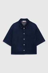 Camisa vaquera de manga corta y corte ligeramente boxy, confeccionada en denim de algodón color azul marino con textura lisa y tejido diagonal. Cuenta con cuello clásico, cierre frontal con botones metálicos y doble pespunte.