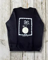 Buzo negro de corte oversize con estampa en la espalda de palmeras y sol con la frase "Sunset Life".