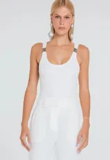 Musculosa de tejido canelado en color gris, con escote redondo y breteles con hebillas metálicas decorativas en los hombros.