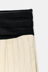 Pantalón de tiro medio Zara Woman Collection, con fajín negro a contraste, pliegues delanteros, pernera ancha, bolsillos laterales ocultos y cierre lateral con cremallera.