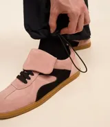 Pantalón cargo negro de corte recto con bolsillos laterales tipo cargo. Presenta cintura elástica con cordón de ajuste y sistema de tiradores en la parte inferior para regular el largo, permitiendo convertirlo en bermuda.