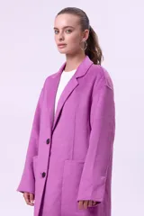 Tapado de lana color fucsia, con solapas clásicas, cierre frontal de dos botones y bolsillos laterales amplios. Diseño de corte recto y largo medio.