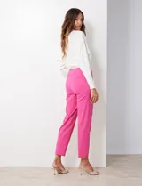 Pantalón de gabardina elastizada color fucsia, de corte recto y pretina ancha pespunteada. Tiene bolsillos simulados.