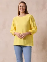 Blusa amarilla texturada con escote redondo y mangas 3/4 con puño elastizado. Aplique de broderie en escote y mangas. Marca Ruby Rd.