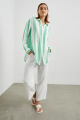Camisa oversize a rayas verticales blancas y verde agua, de gasa de algodón, con bolsillo en el pecho y mangas largas. Inspirada en la ropa masculina.