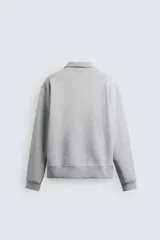 Sudadera roja de corte regular, con cuello alto y cierre frontal de cremallera. Manga larga y terminaciones en rib.