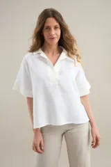 Blusa blanca de lino con silueta cómoda y relajada, escote en V con cuello polo y detalles en algodón.