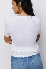 Remera de algodón en punto suave, de corte entallado con cuello redondo y mangas cortas.