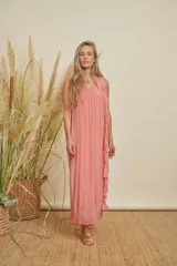 Vestido largo color salmón, con escote redondo, sin mangas y detalle de volados en un lateral.