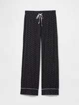 Pantalón de pijama de modal negro con estampado de pequeños puntos blancos, corte recto y cintura elástica con cordón ajustable. Presenta un detalle de vivo en el ruedo.