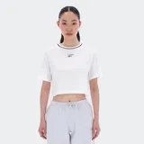 Remera corta blanca de algodón con cuello redondo ribeteado en negro y logo Reebok bordado en el pecho.