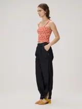 Pantalón tipo bombacha de campo color beige, de corte holgado con pinzas en la cintura y puños ajustados en los tobillos. Presenta costuras a contratono y bolsillos laterales.