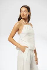 Top blanco de lino con breteles finos elásticos regulables en la espalda y fruncido en el escote y la espalda.