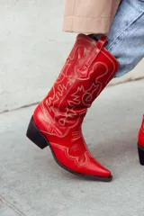 Bota texana roja con bordados en hilo color crema, caña media y taco bajo.