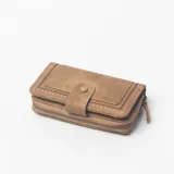 Billetera Delmara color marrón, con cierre perimetral de cremallera y solapa frontal con broche de presión. Presenta detalles de bordado decorativo en los bordes.