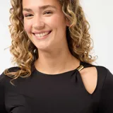 Camiseta de manga larga en color negro, confeccionada en tejido elástico y entallado. Presenta un diseño con cuello redondo y una abertura tipo cut-out en el hombro izquierdo, decorada con un detalle metálico dorado.