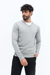 Sweater de punto color gris melange, con escote en V, manga larga y logo bordado en el pecho. Presenta puños y ruedo acanalados.