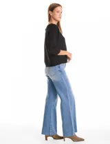 Buzo de silueta relajada confeccionado en tejido acanalado, con cuello redondo y mangas tres cuartos estilo japonés. Presenta un diseño fluido y cómodo.