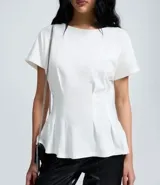 Blusa de algodón color blanco con cuello redondo y mangas cortas. Presenta un diseño peplum con pliegues en la cintura que realzan la silueta.